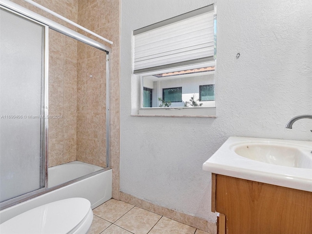 full bathroom featuring tile patterned flooring, toilet, combined bath / shower with glass door, and vanity