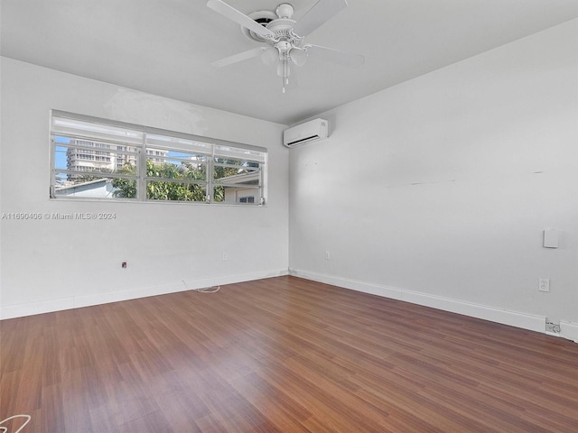 spare room featuring an AC wall unit, ceiling fan, and wood-type flooring