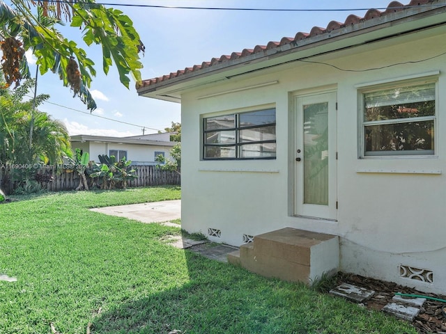 entrance to property with a patio area and a yard