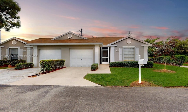 single story home with a lawn and a garage