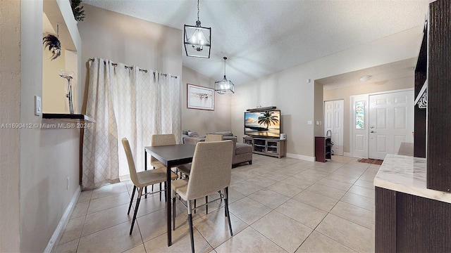 tiled dining space with a textured ceiling, vaulted ceiling, and a notable chandelier