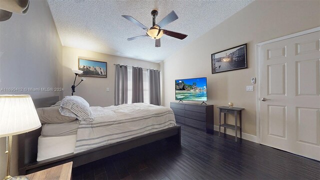 bedroom featuring ceiling fan, dark hardwood / wood-style floors, a textured ceiling, and vaulted ceiling