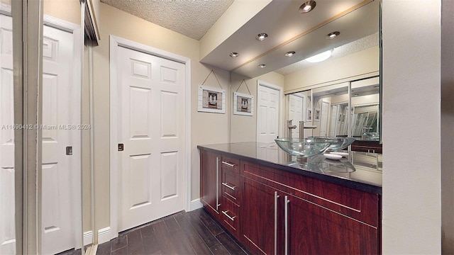 interior space featuring dark hardwood / wood-style flooring, sink, and a textured ceiling