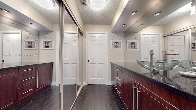 bathroom featuring hardwood / wood-style flooring, vanity, and a textured ceiling