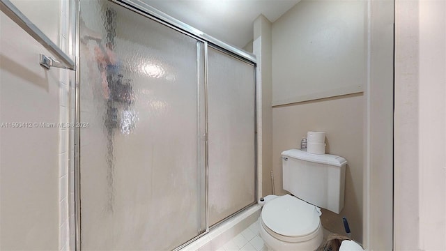 bathroom with a shower with shower door, tile patterned flooring, and toilet