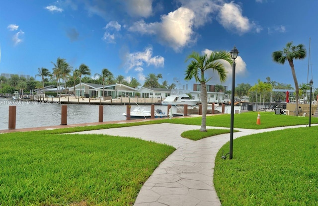 view of dock with a water view and a yard