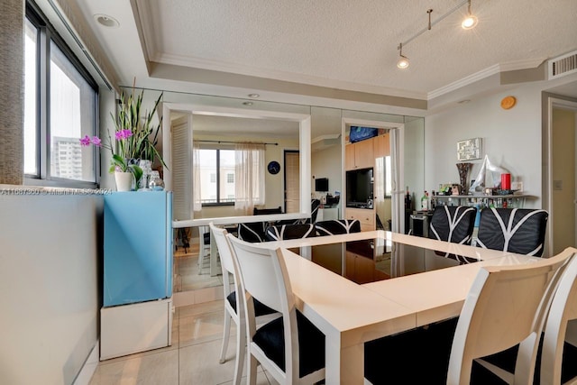 kitchen with ornamental molding, a textured ceiling, and light tile patterned floors