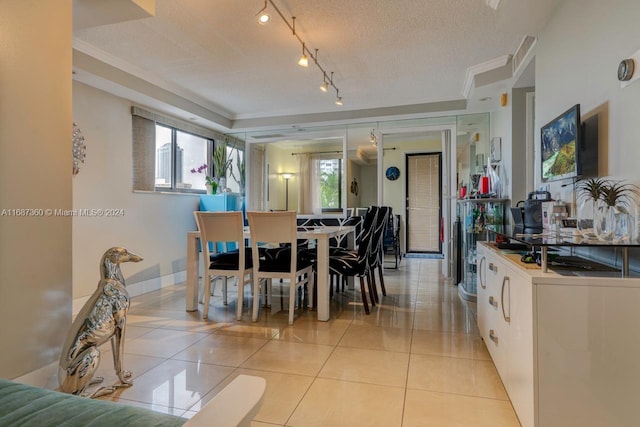 tiled dining room featuring a textured ceiling and crown molding