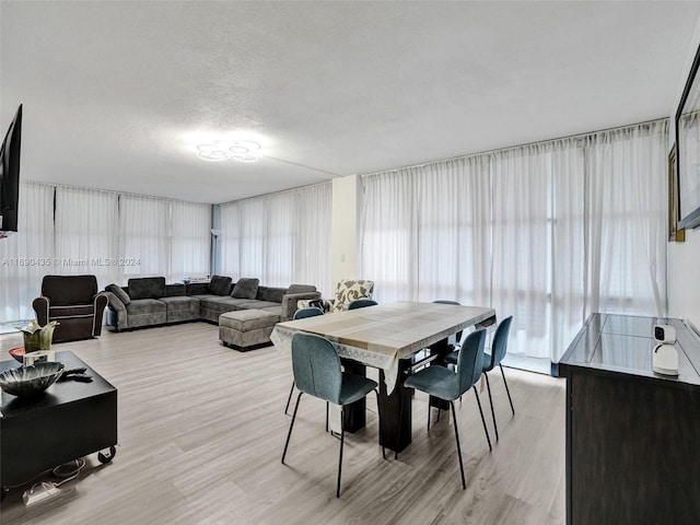 dining space featuring a textured ceiling and light hardwood / wood-style flooring