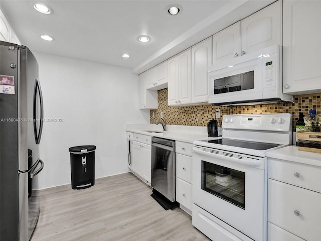 kitchen with white cabinets, decorative backsplash, light hardwood / wood-style flooring, sink, and appliances with stainless steel finishes