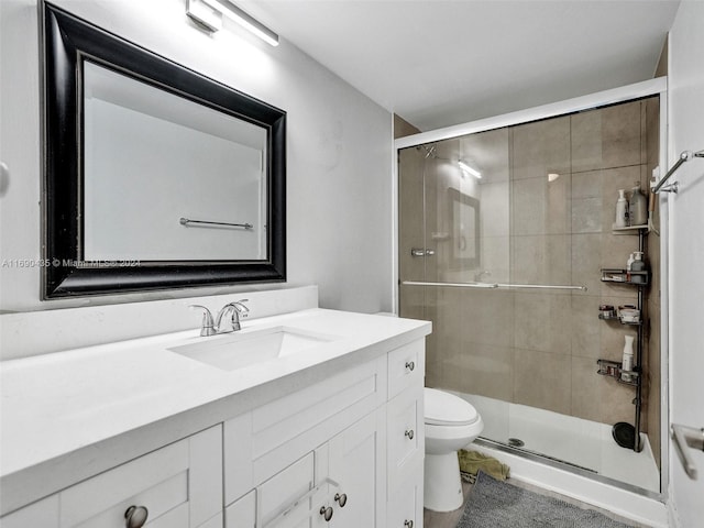 bathroom with an enclosed shower, vanity, and toilet