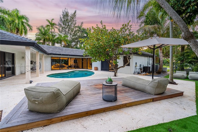 pool at dusk featuring a deck