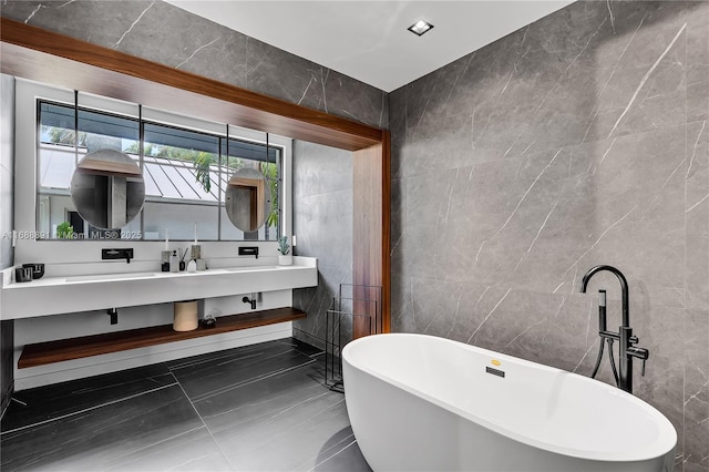 full bathroom featuring a soaking tub, vanity, and tile walls