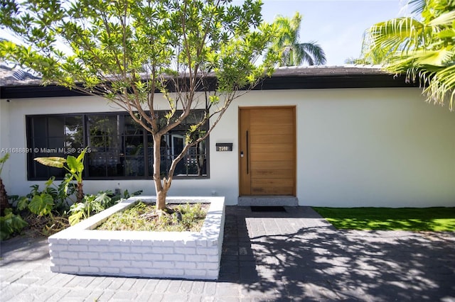 property entrance with stucco siding