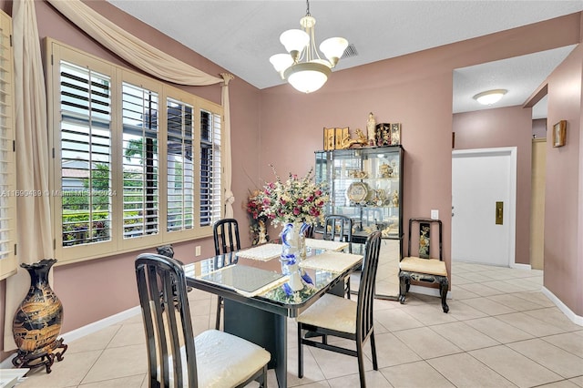 dining room featuring a textured ceiling, a notable chandelier, and light tile patterned flooring