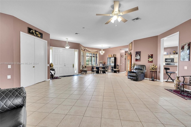 living room with ceiling fan with notable chandelier and light tile patterned floors