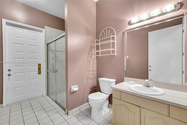 bathroom with toilet, vanity, tile patterned floors, and a shower with door