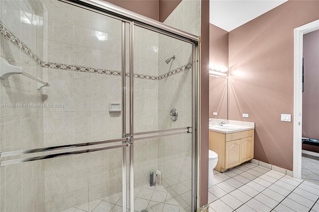 bathroom with toilet, vanity, tile patterned flooring, and a shower with door