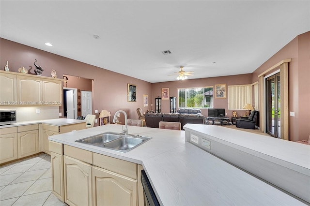 kitchen featuring light tile patterned flooring, ceiling fan, sink, and stainless steel microwave