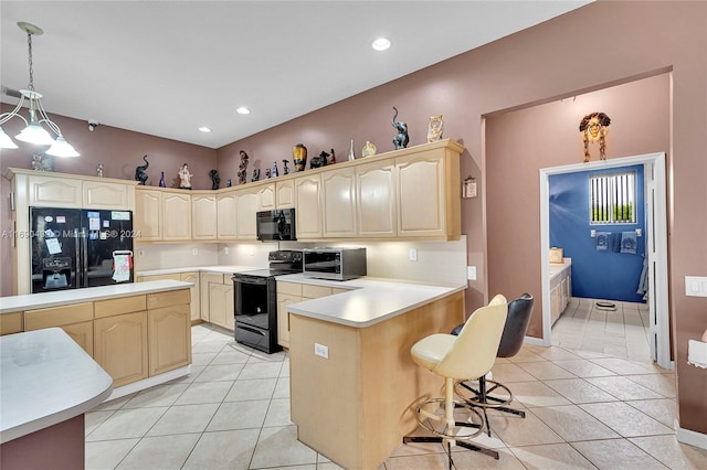 kitchen featuring light tile patterned flooring, a breakfast bar, black appliances, kitchen peninsula, and hanging light fixtures