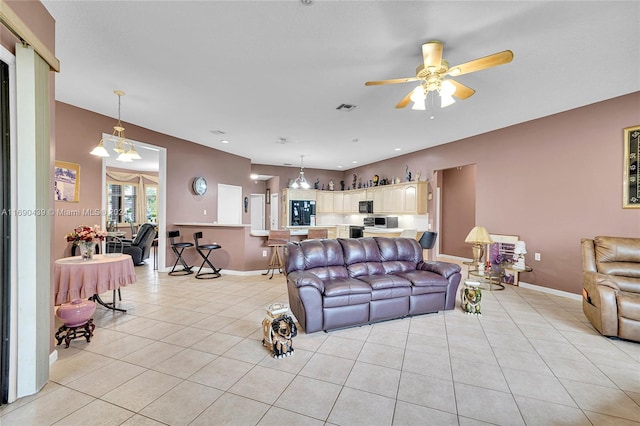 tiled living room with ceiling fan with notable chandelier