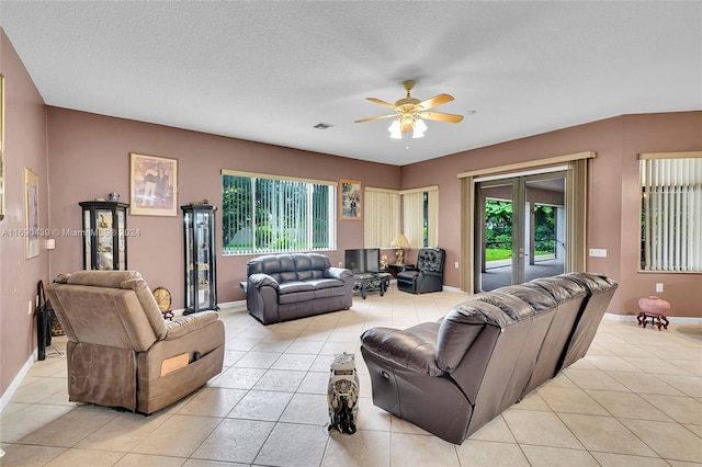 tiled living room featuring a wealth of natural light, french doors, and a textured ceiling