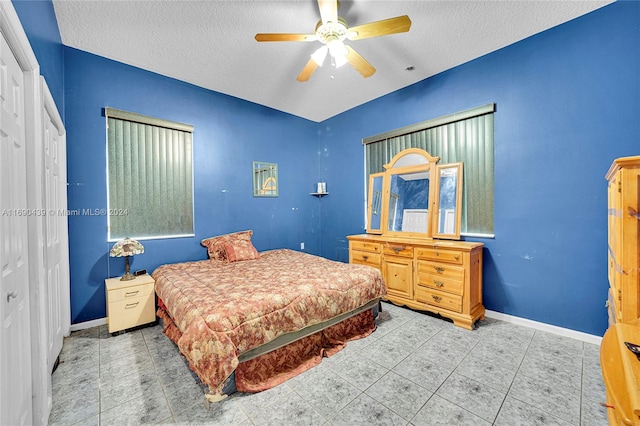 bedroom with a textured ceiling, ceiling fan, and a closet