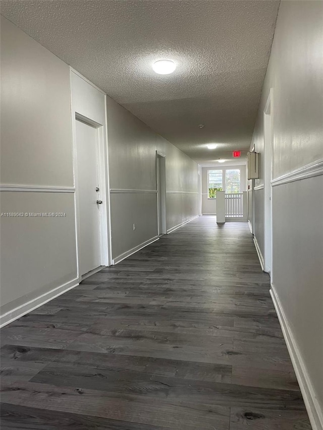 hall with dark hardwood / wood-style flooring and a textured ceiling