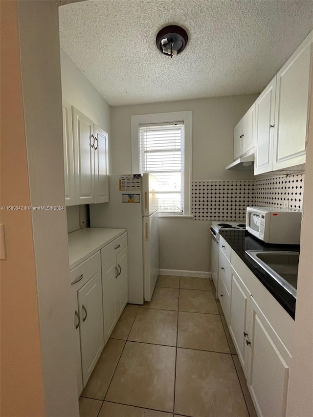 kitchen with decorative backsplash, white cabinetry, a textured ceiling, and light tile patterned flooring