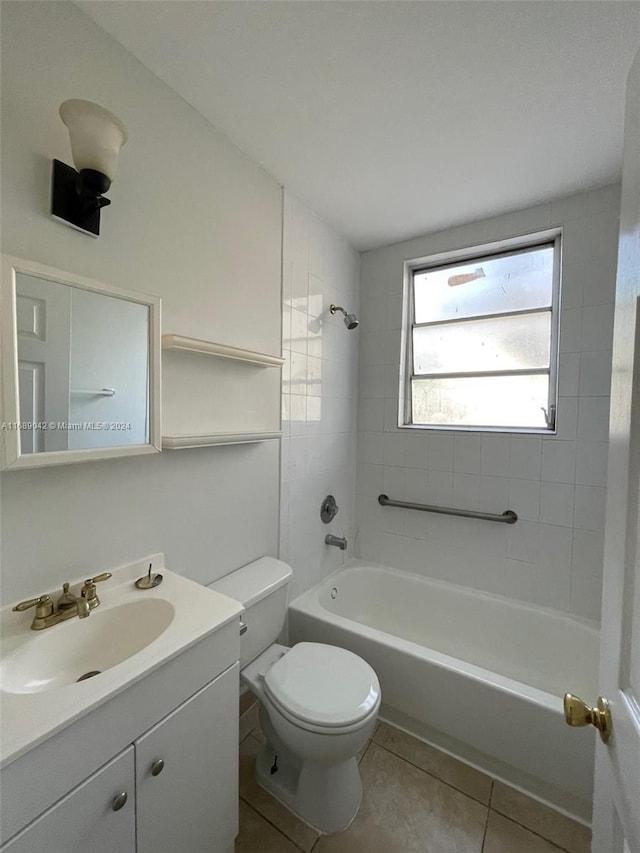 full bathroom featuring vanity, tile patterned floors, toilet, and tiled shower / bath combo