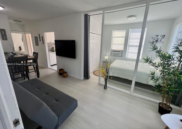 bedroom with cooling unit and light hardwood / wood-style floors