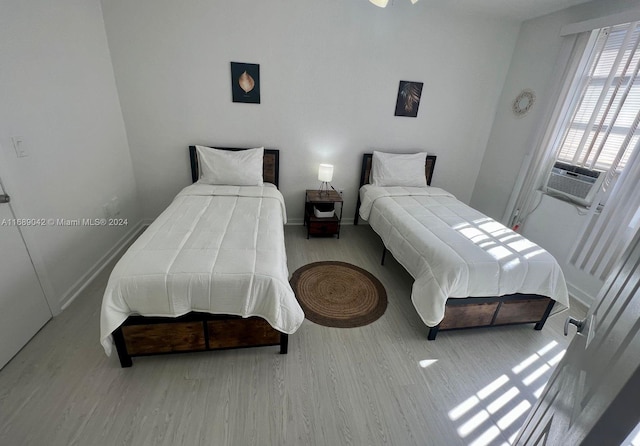 bedroom with light wood-type flooring and cooling unit