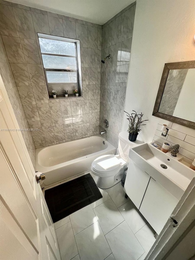 full bathroom featuring vanity, tile patterned flooring, tiled shower / bath, and toilet