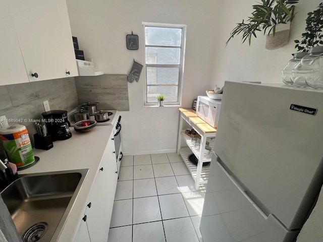 kitchen featuring sink, extractor fan, light tile patterned floors, white appliances, and white cabinets