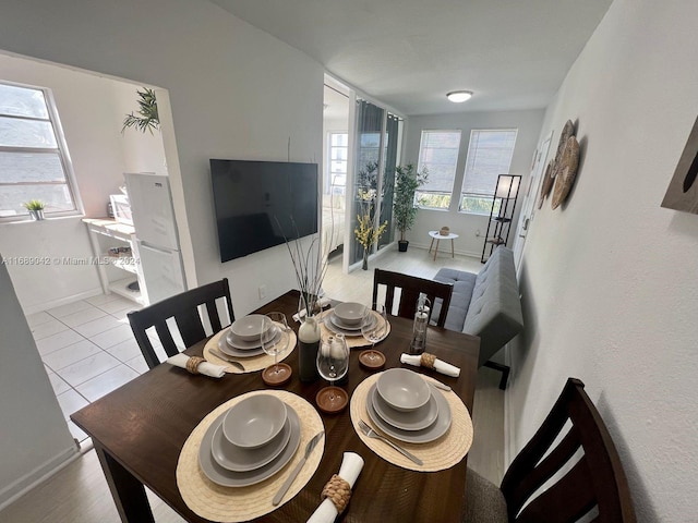 tiled dining space with a healthy amount of sunlight