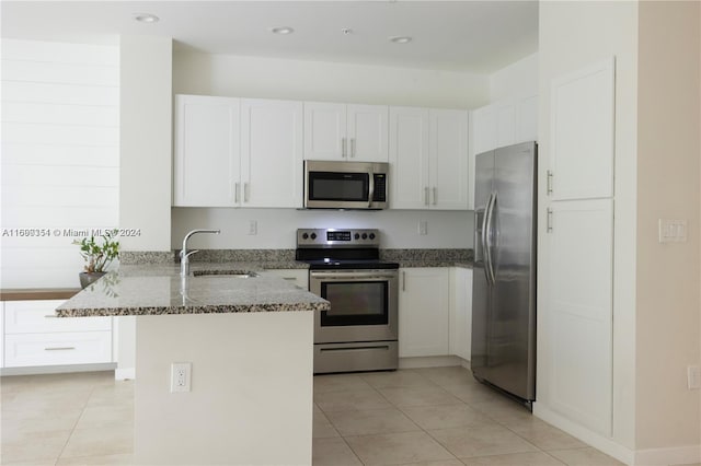 kitchen with dark stone countertops, sink, white cabinets, and stainless steel appliances