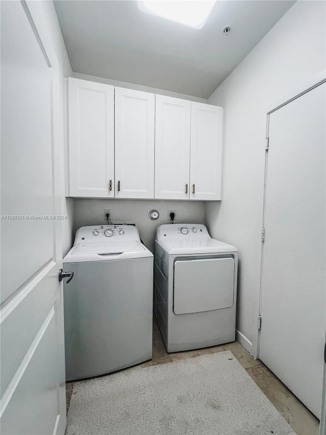 washroom with cabinets and washer and clothes dryer