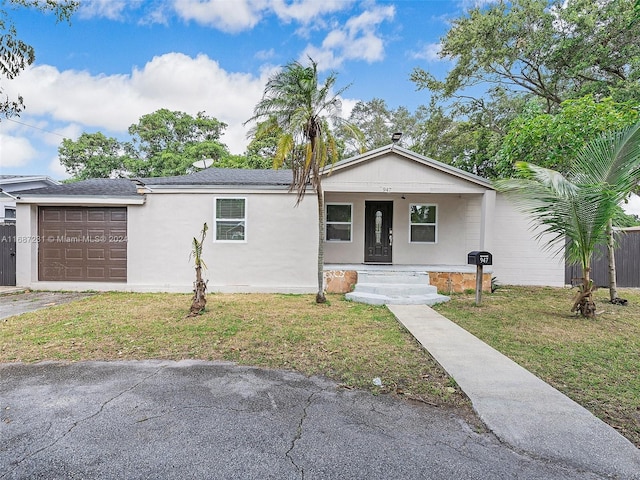 ranch-style home with a porch, a garage, and a front lawn