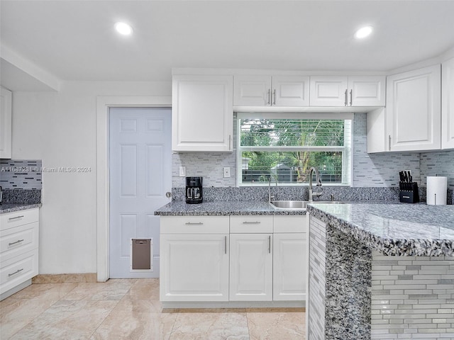 kitchen with white cabinets, backsplash, and sink