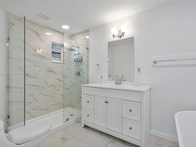 bathroom with toilet, vanity, and tiled shower