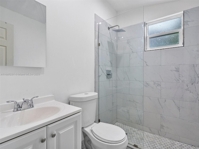 bathroom featuring toilet, vanity, and tiled shower