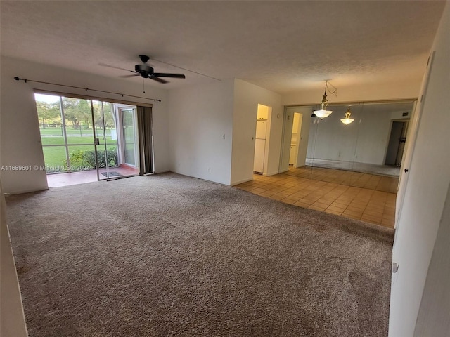 empty room featuring a textured ceiling, light colored carpet, and ceiling fan