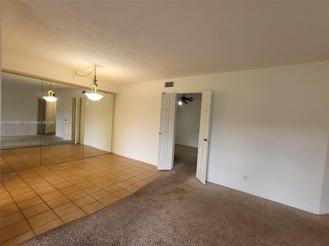 tiled spare room featuring ceiling fan and a textured ceiling