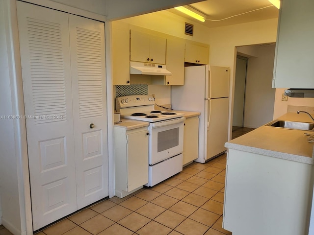 kitchen featuring white appliances, sink, and light tile patterned floors