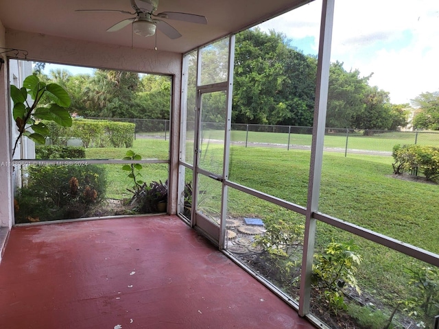 unfurnished sunroom with ceiling fan