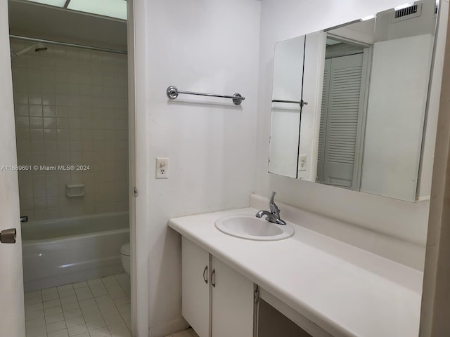 full bathroom featuring vanity, tile patterned floors, toilet, and tiled shower / bath combo