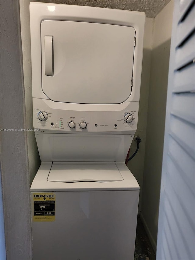 washroom with stacked washer and clothes dryer and a textured ceiling