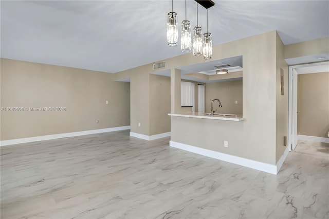 kitchen with stainless steel appliances, sink, kitchen peninsula, and decorative light fixtures