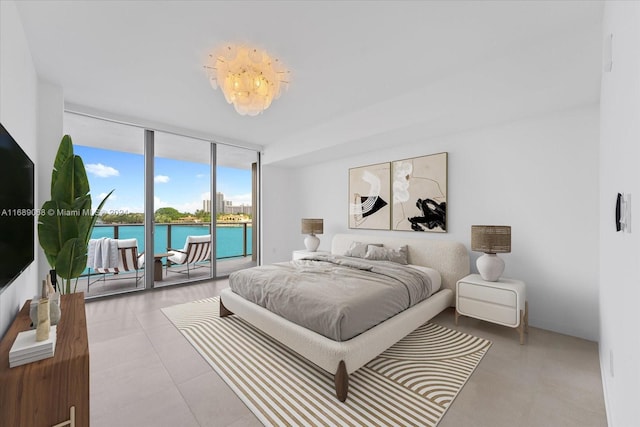 bedroom featuring access to exterior, a water view, and a wall of windows