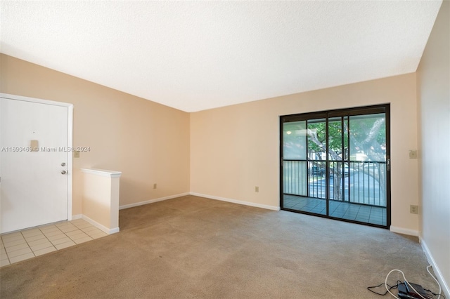 carpeted spare room featuring a textured ceiling